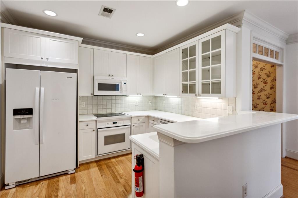 4100 Paces Walk Southeast, Unit 3205 Atlanta, GA 30339 - Photo 10 of 17 a kitchen with stainless steel appliances granite countertop a sink a stove a refrigerator and white cabinets with wooden floor