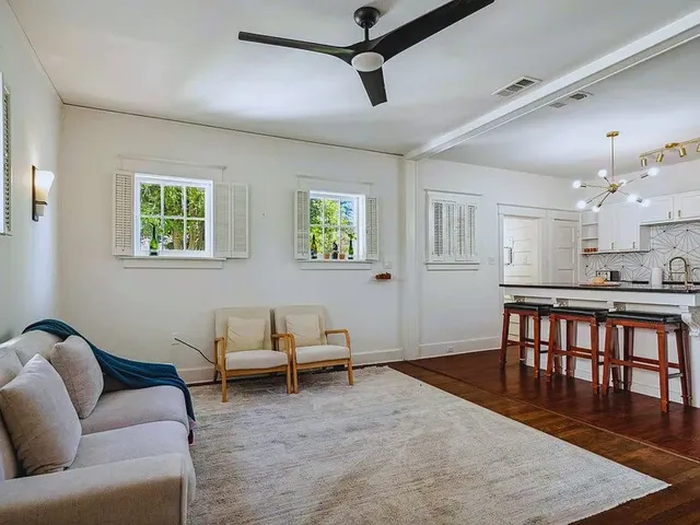 a living room with furniture wooden floor and windows