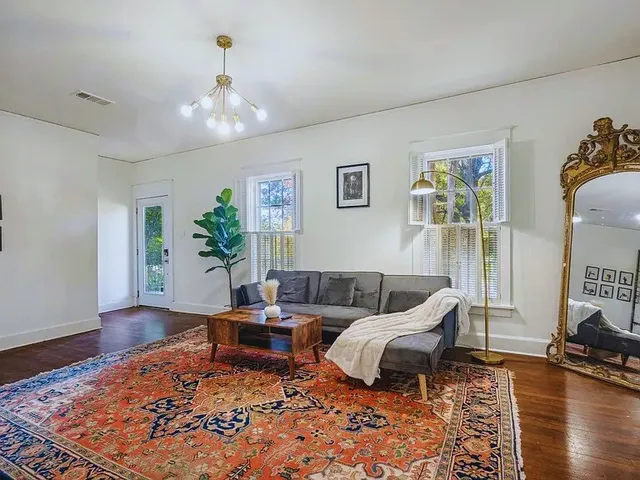 a living room with furniture and wooden floor
