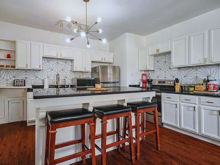 816 Charles Place Memphis, TN 38112 - Photo 7 of 24 a kitchen with stainless steel appliances granite countertop a table chairs sink and cabinets