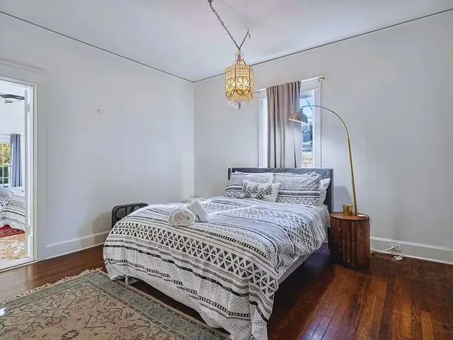 a bedroom with a bed and wooden floor