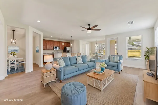 a living room with furniture kitchen view and a large window