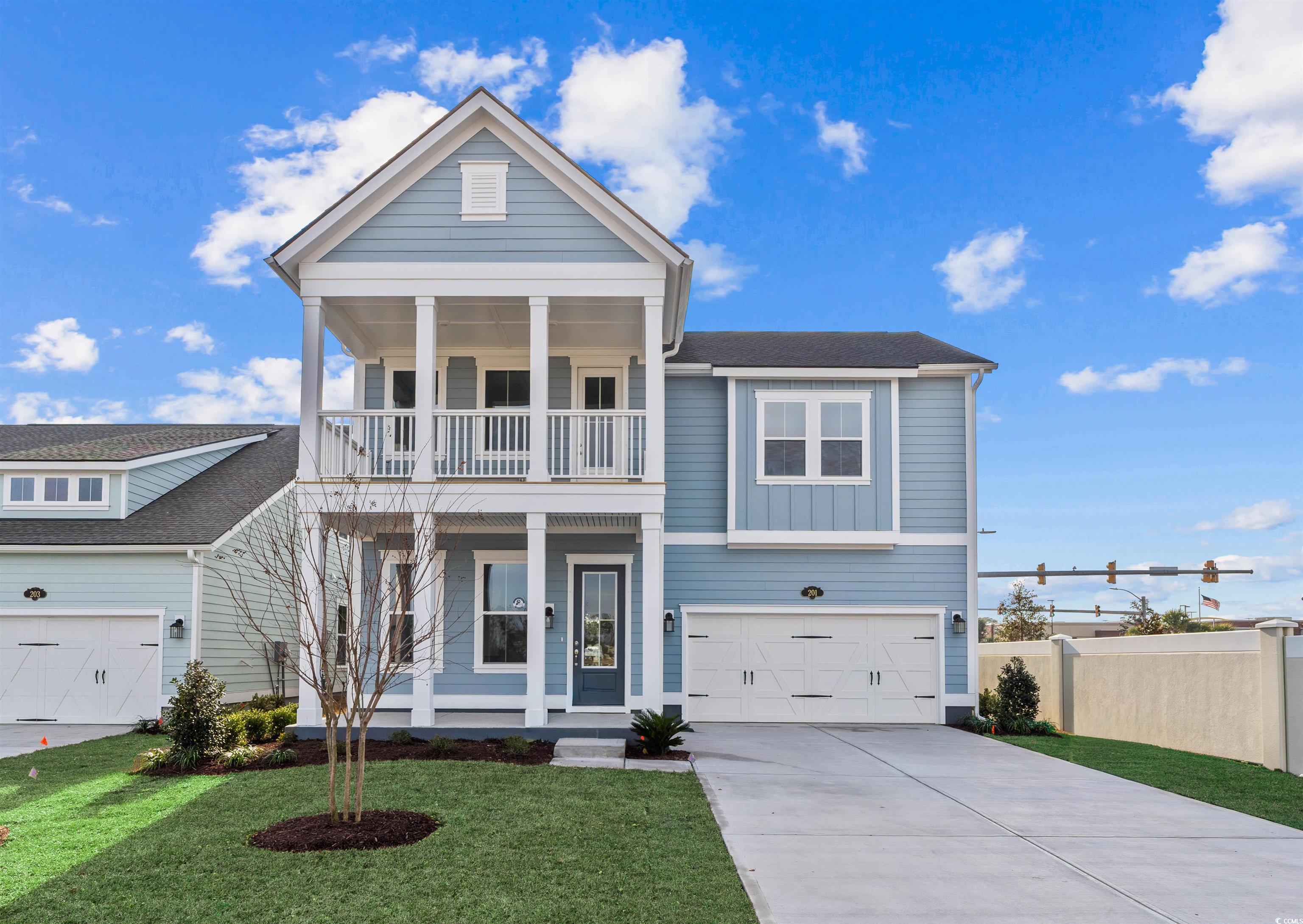 View of front of property with a porch, concrete driveway, a garage, and board and batten siding