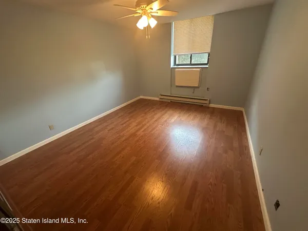a small room with a wooden floor and shower
