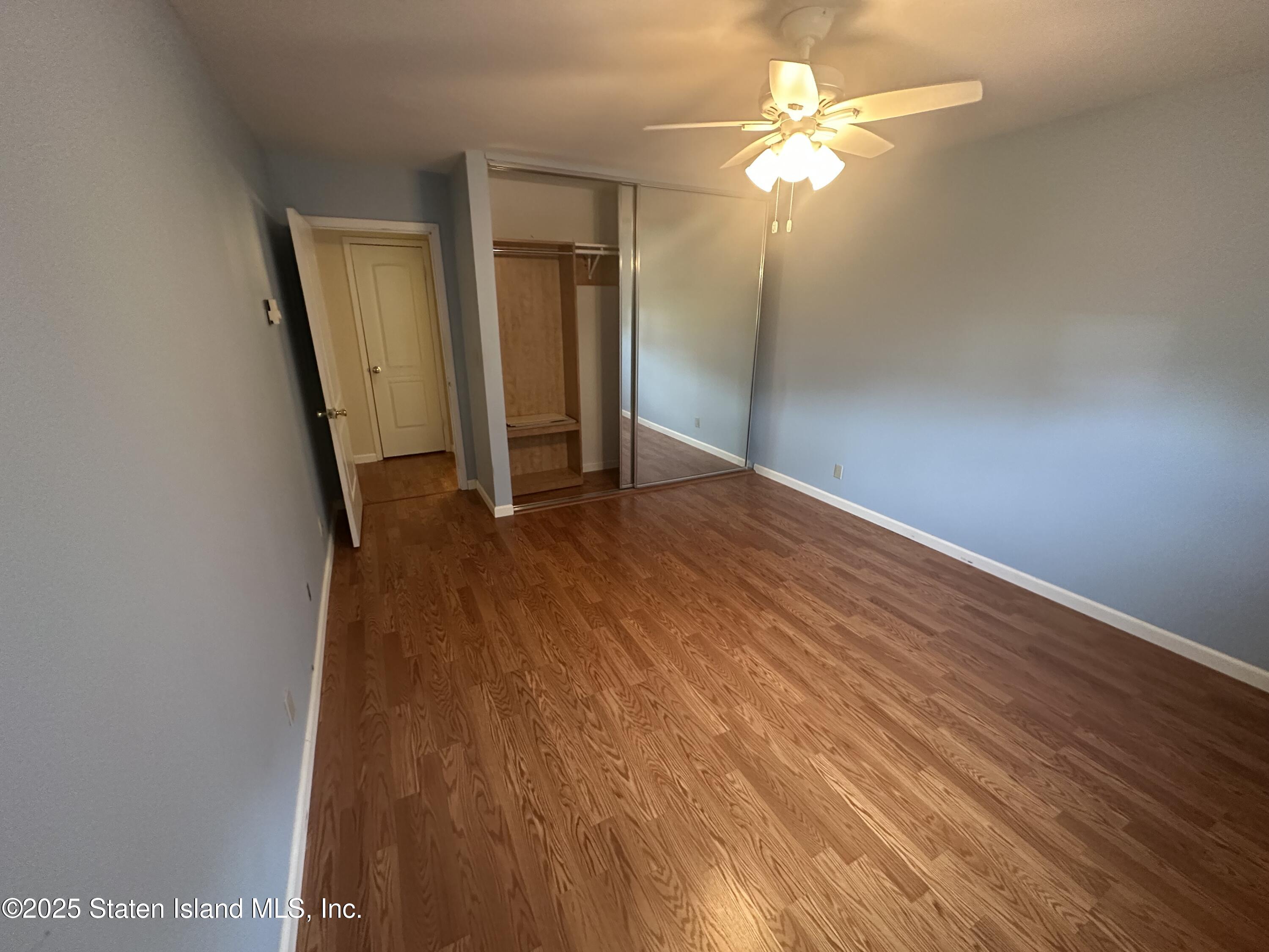 50 Belair Road, Unit 1E Staten Island, NY 10305 - Photo 10 of 12 wooden floor in an empty room with a window