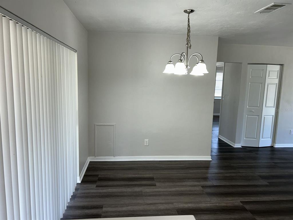 1241 Pilgrim Road Spring Hill, FL 34606 - Photo 7 of 28 a view of a hallway with wooden floor and staircase
