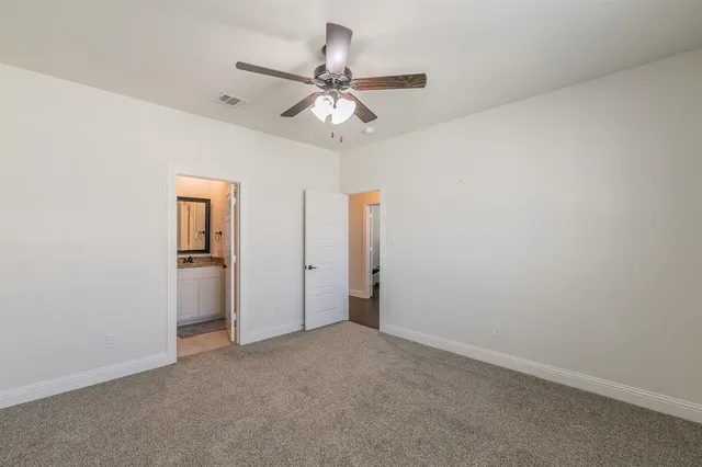 an empty room with closet and a chandelier fan