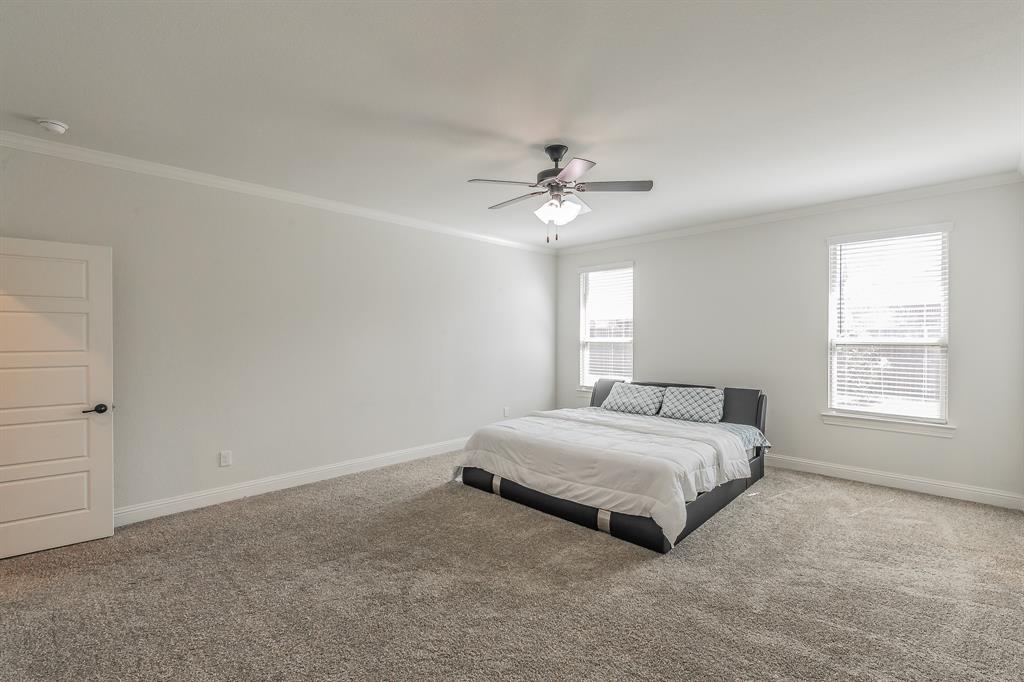 3424 Cimarron River Drive Prosper, TX 75078 - Photo 23 of 40 a spacious bedroom with a bed and a chandelier
