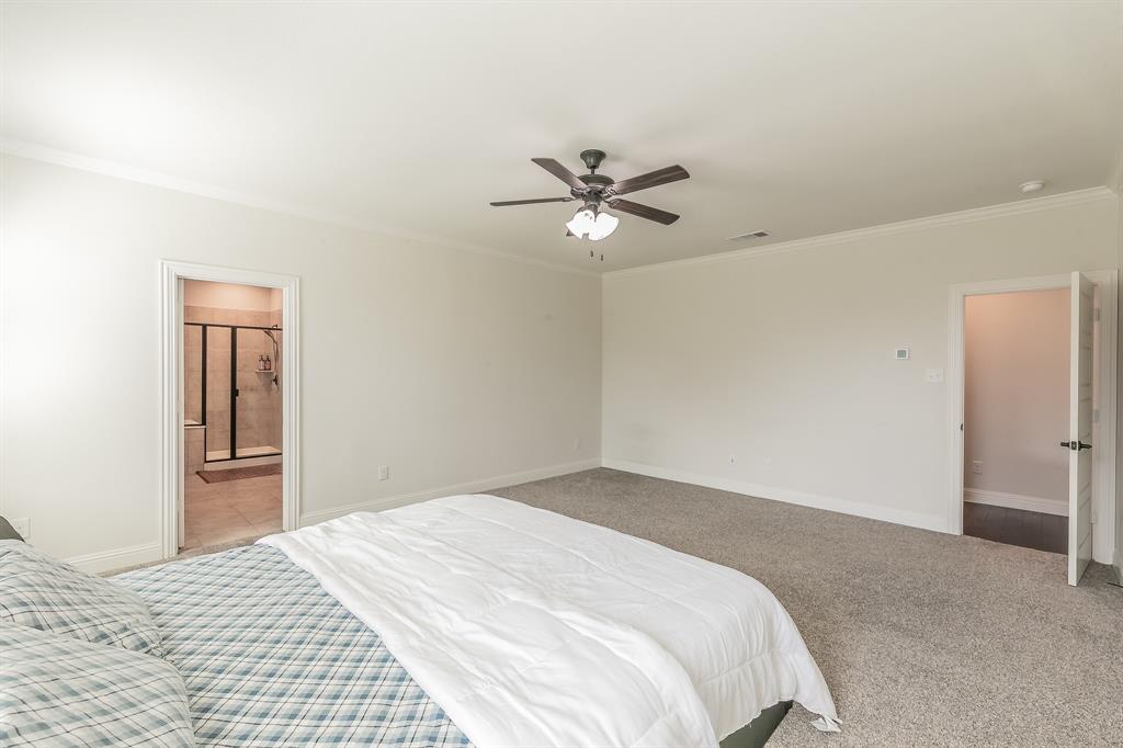 3424 Cimarron River Drive Prosper, TX 75078 - Photo 25 of 40 a bedroom with a large bed and a chandelier