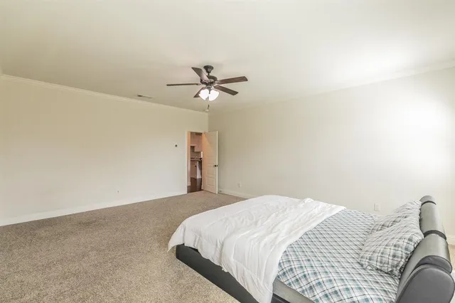 a bedroom with a bed and a ceiling fan
