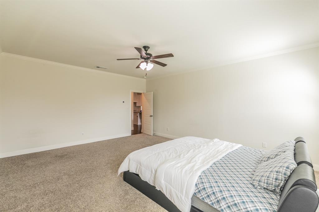 3424 Cimarron River Drive Prosper, TX 75078 - Photo 27 of 40 a bedroom with a bed and a ceiling fan