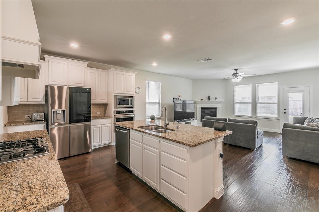 3424 Cimarron River Drive Prosper, TX 75078 - Photo 40 of 40 a kitchen that has a lot of cabinets a sink and appliances in it