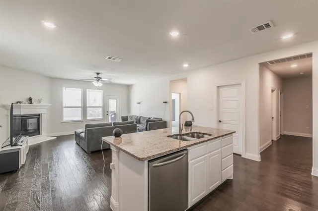 a kitchen that has a lot of cabinets a sink and appliances in it