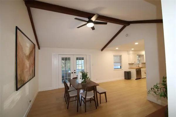 a dining room with wooden floor a chandelier a wooden table and chairs