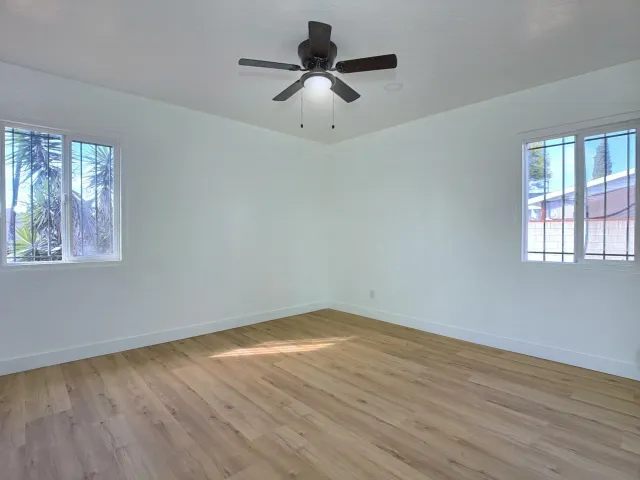 a view of an empty room with wooden floor