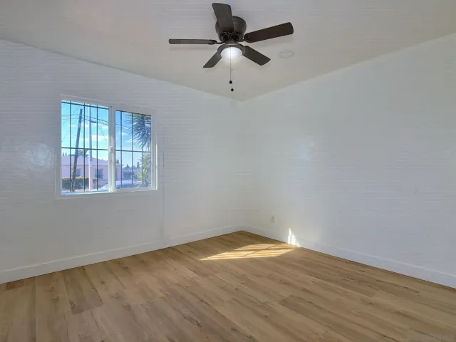 a view of empty room with wooden floor