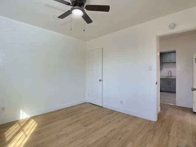 a view of a livingroom with wooden floor and a ceiling fan