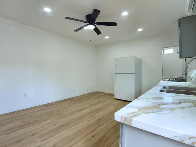 a kitchen with wooden floors and white cabinets