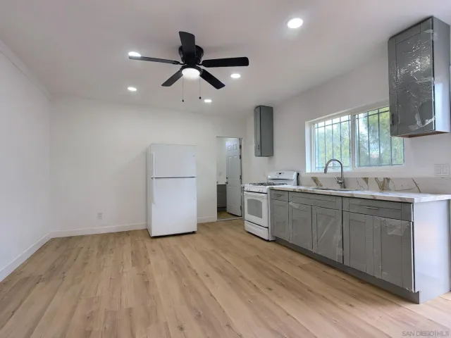 a kitchen with stainless steel appliances granite countertop a stove cabinets and wooden floor