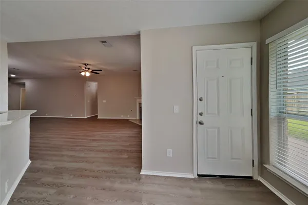 an empty room with wooden floor and windows