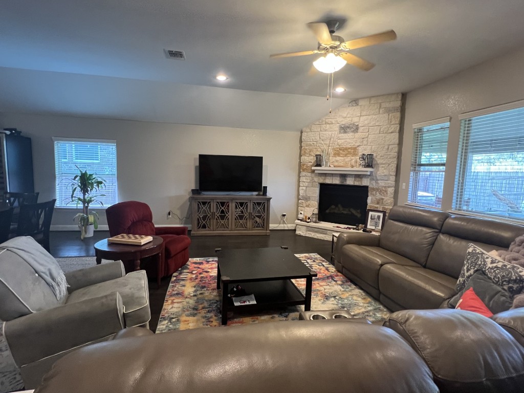 404 Peakside Circle Dripping Springs, TX 78620 - Photo 3 of 9 Living room with vaulted ceiling, plenty of natural light, a stone fireplace, a ceiling fan, and recessed lighting