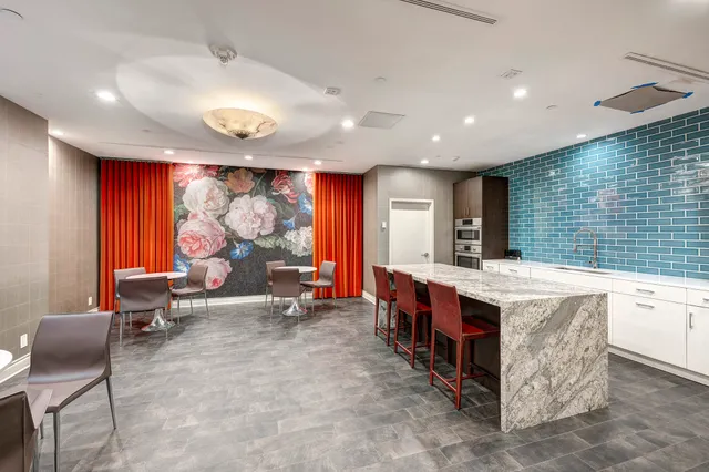 a large kitchen with stainless steel appliances a stove a sink and a refrigerator