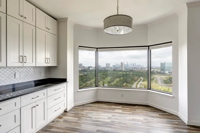 a kitchen with granite countertop white cabinets and a large window