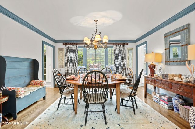 a dining room with furniture a chandelier and wooden floor