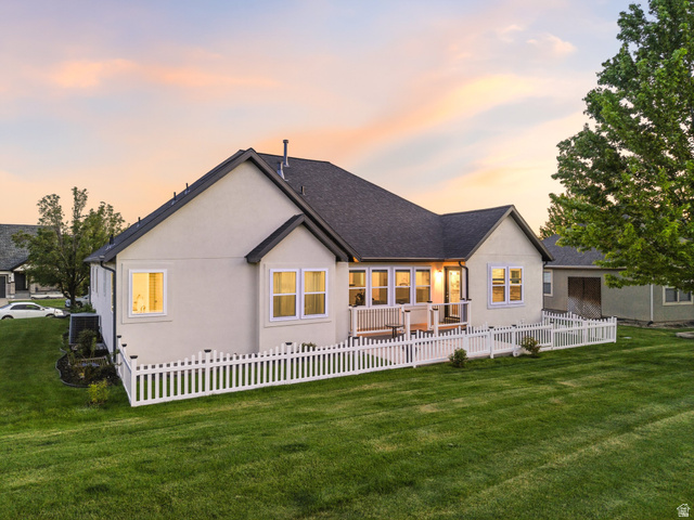 6242 Apollo Way Highland, UT 84003 - Photo 42 of 47 Rear exterior featuring a white picket fence, expansive green lawn, and a spacious deck