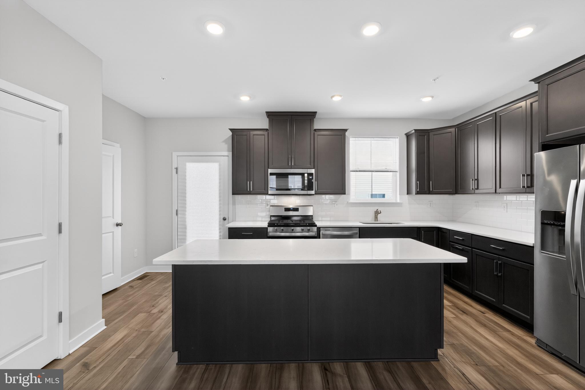 70 Continental Way Bridgeport, PA 19405 - Photo 3 of 30 a large kitchen with stainless steel appliances wooden floors and wooden cabinets