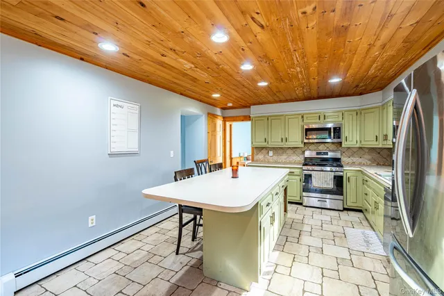 a kitchen with stainless steel appliances kitchen island granite countertop a sink a counter top space and cabinets
