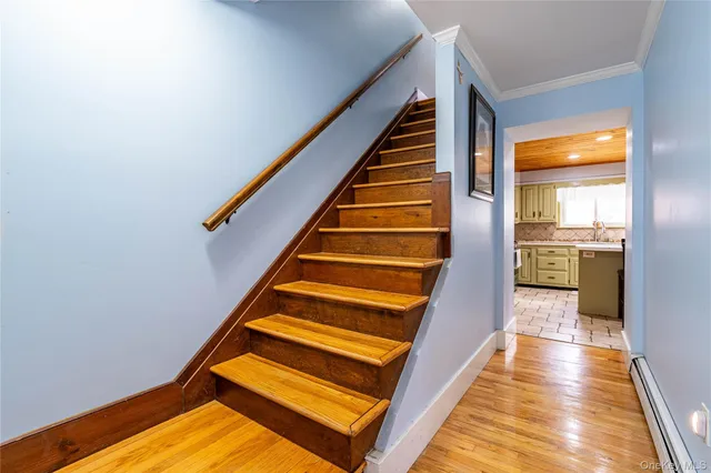 a view of entryway and hall with wooden floor