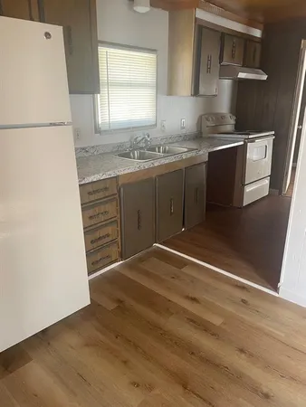 a kitchen with a sink cabinets and a refrigerator