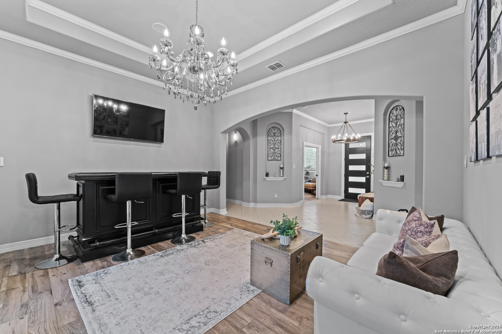 27906 Bogen Road New Braunfels, TX 78132 - Photo 28 of 49 a living room with furniture a chandelier and a flat screen tv