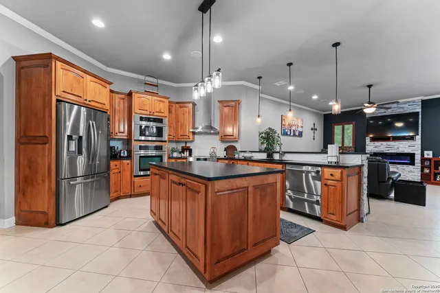 a large kitchen with stainless steel appliances granite countertop a stove a refrigerator a oven and a sink