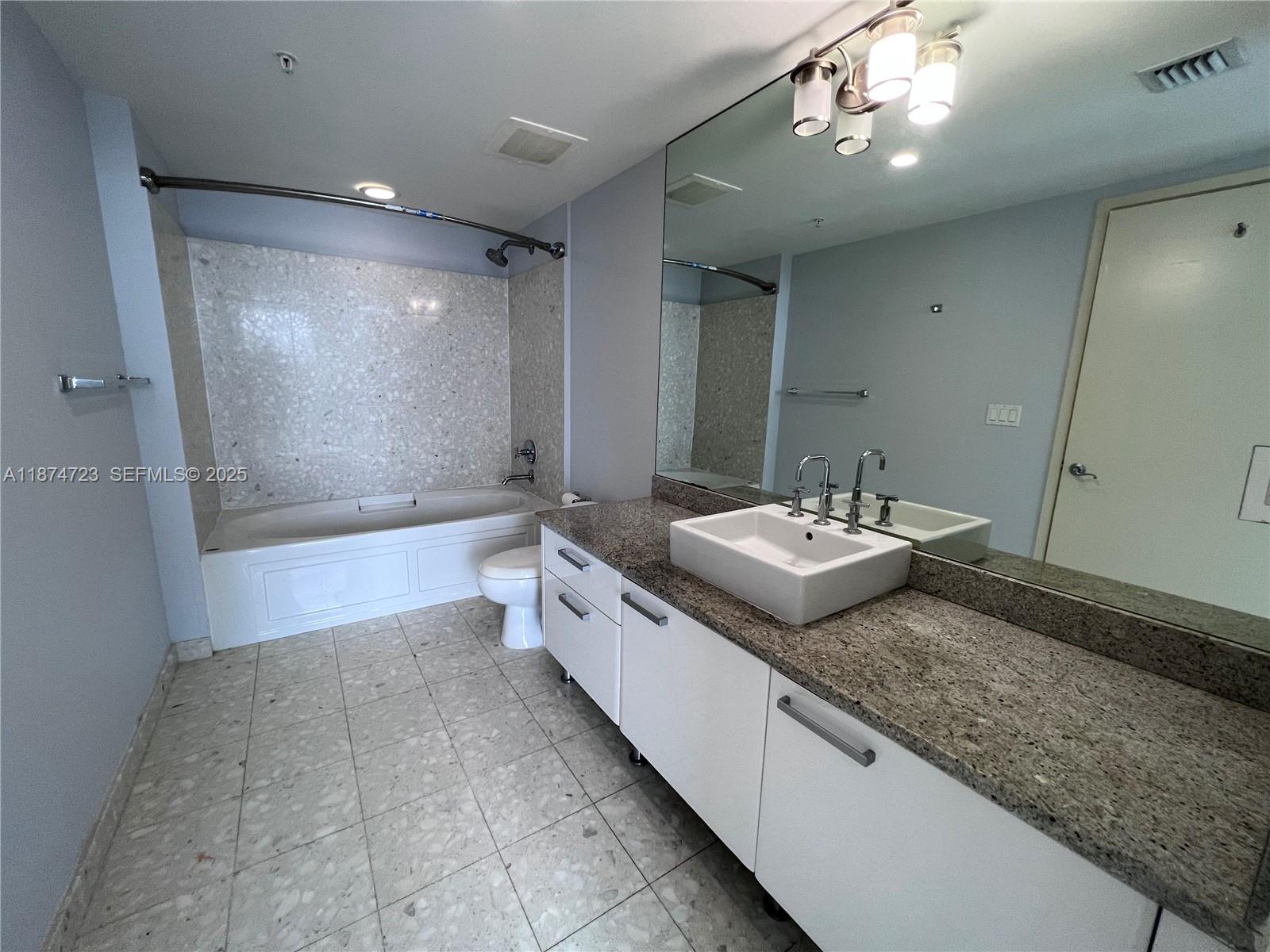 185 Southwest 7th Street, Unit 4204 Miami, FL 33130 - Photo 14 of 32 a bathroom with a sink a large mirror and a shower