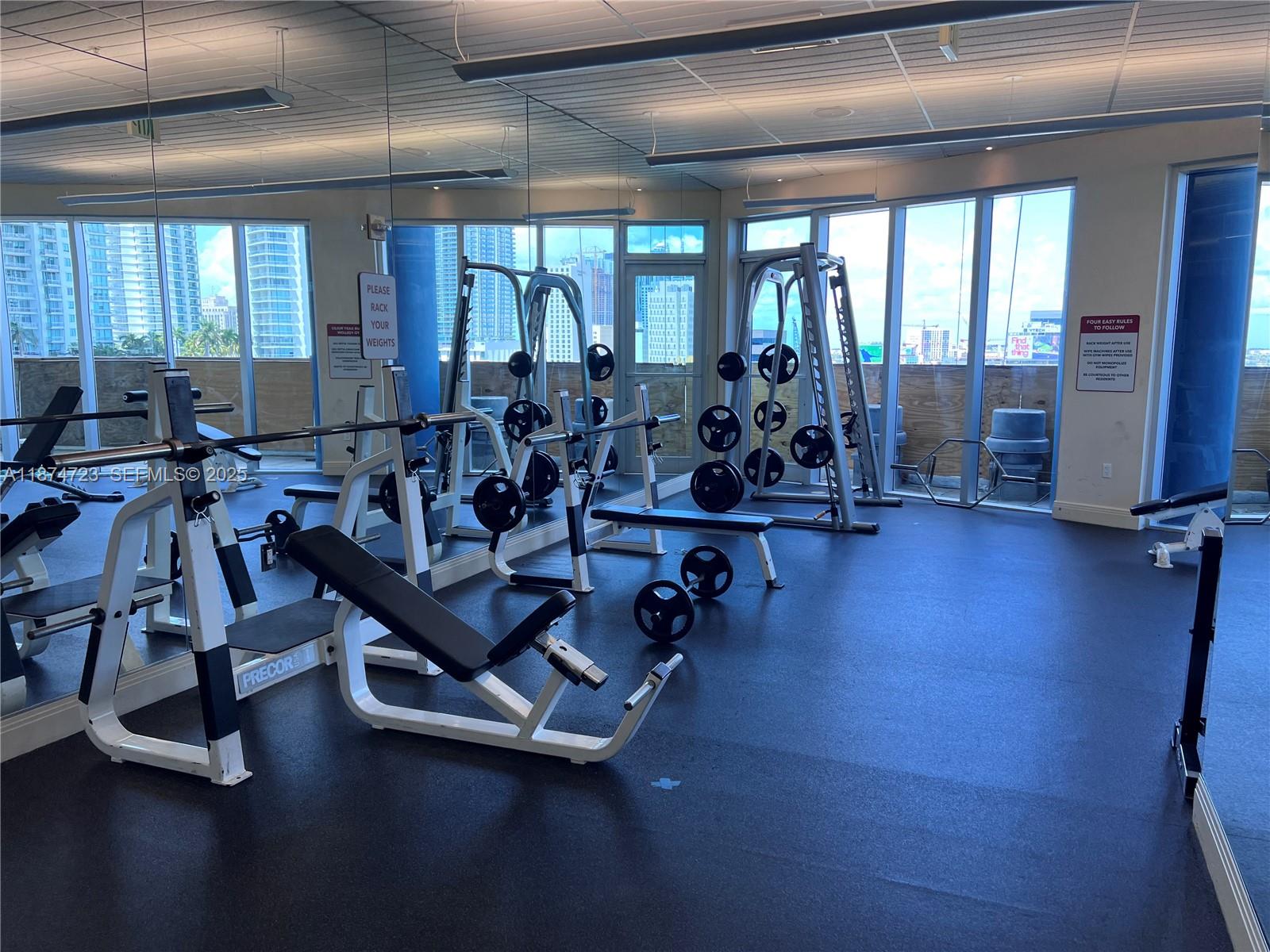 185 Southwest 7th Street, Unit 4204 Miami, FL 33130 - Photo 23 of 32 a room with gym equipment and large mirror