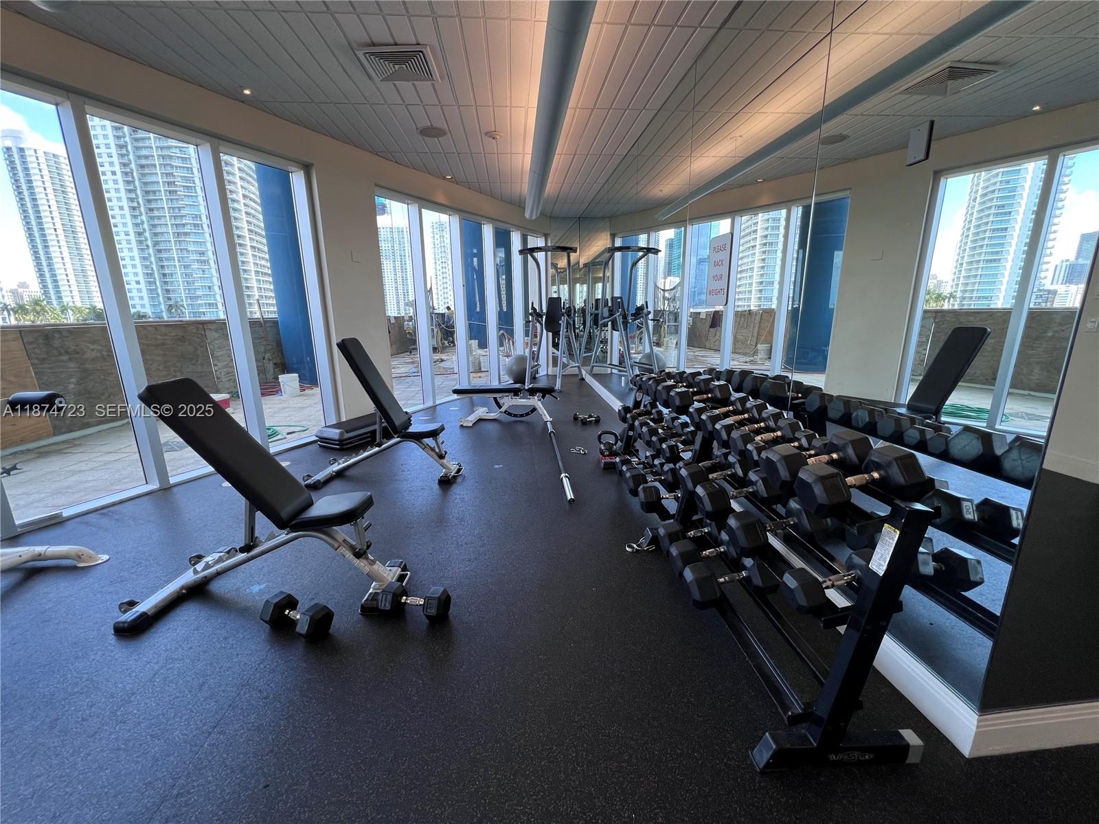 185 Southwest 7th Street, Unit 4204 Miami, FL 33130 - Photo 24 of 32 a room with gym equipment and a large window