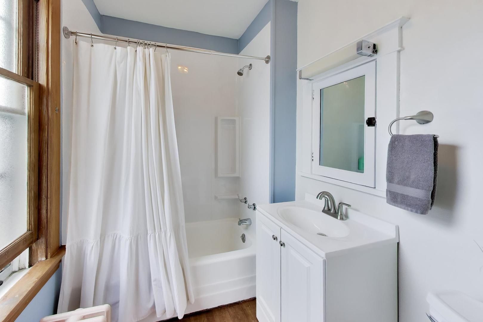 3533 Grand Boulevard Brookfield, IL 60513 - Photo 29 of 40 a bathroom with a sink a mirror and a shower