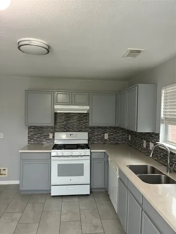 a kitchen with a stove sink and cabinets
