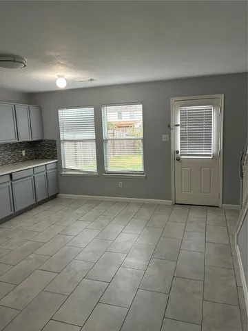 a view of an empty room with a kitchen