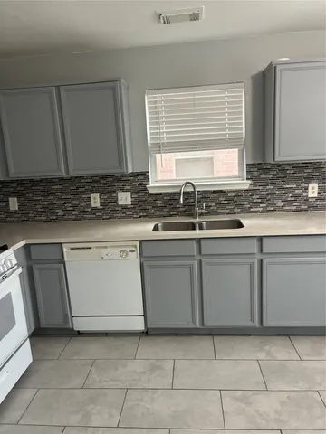 a kitchen with a sink stove and cabinets