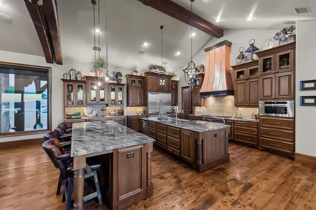 a kitchen with stainless steel appliances granite countertop a stove and a wooden cabinets