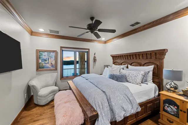 a bedroom with a bed a couch and a flat tv screen on the dresser