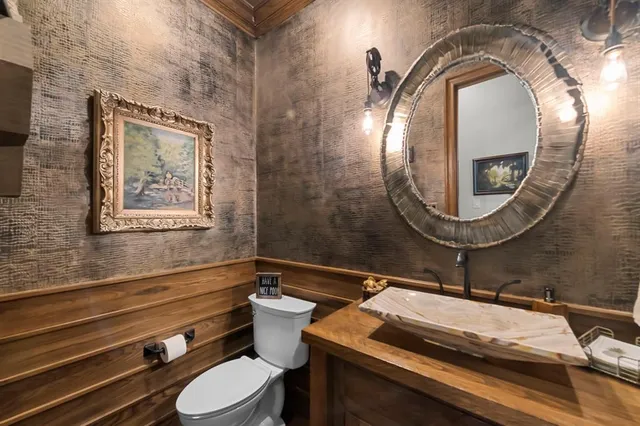 a bathroom with a granite countertop sink a toilet and mirror