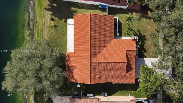 an aerial view of a house with a yard and lake view