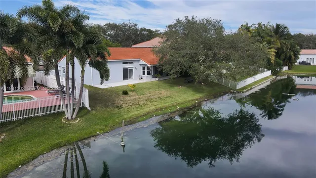 an aerial view of residential houses with outdoor space and trees