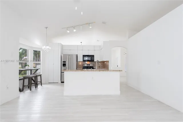 a living room with furniture and a dining table with kitchen view