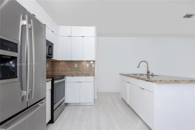 a kitchen with stainless steel appliances granite countertop a sink and a stove top oven
