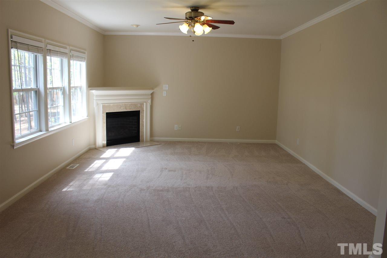 1817 White Dogwood Road Apex, NC 27502 - Photo 5 of 13 en empty room with windows and fireplace